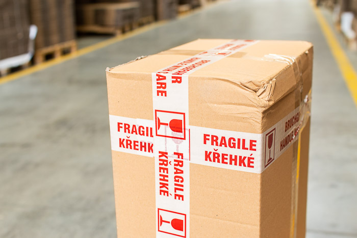 Poškodená kartónová krabica s lepiacou páskou Krehké/Fragile